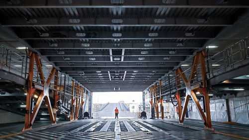 Rear view of people walking in tunnel
