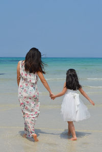 Mom and daughter walking on the beach of woljeonri beach, jeju island, south korea