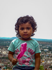 Portrait of cute girl standing against sky