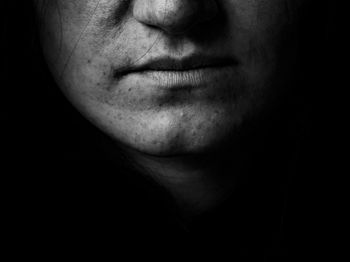 Close-up of woman face against black background