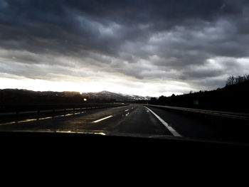 Highway against sky seen through car windshield