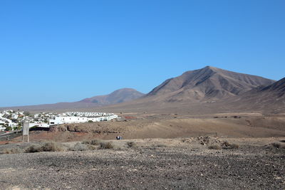 Scenic view of desert against clear blue sky