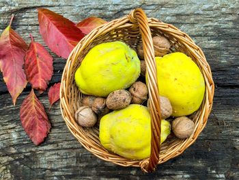 High angle view of food in basket by autumn leaves on table