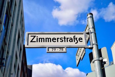 Low angle view of information sign against sky