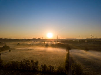 Scenic view of field against clear sky during sunset