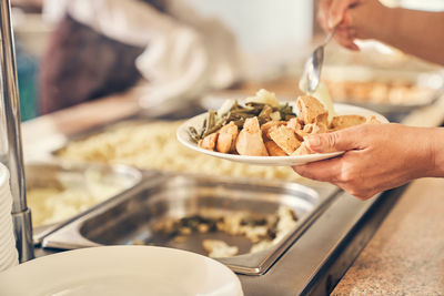 Cropped hand of person preparing food