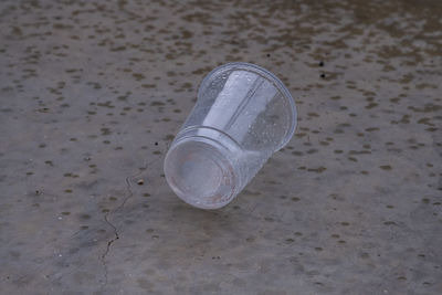 High angle view of glass bottle on sand