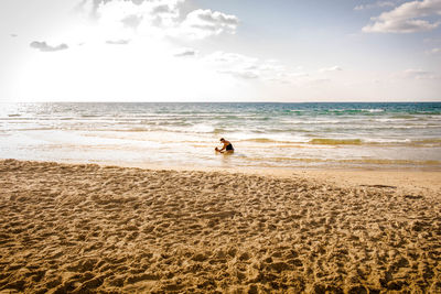 Woman with baby standing in sea