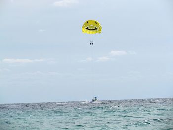 People paragliding over sea against sky