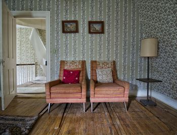 Empty chairs against wall at home