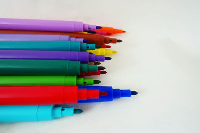 High angle view of colored pencils against white background