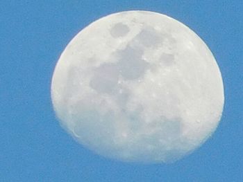 Low angle view of moon against blue sky