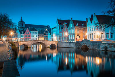 Arch bridge over canal by buildings in town