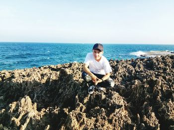 Full length of boy standing on beach against clear sky