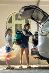 Side view of woman sitting on car