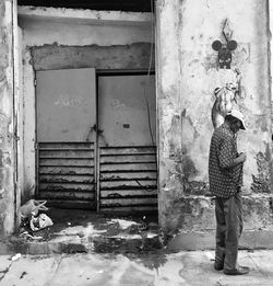 Man standing against abandoned building