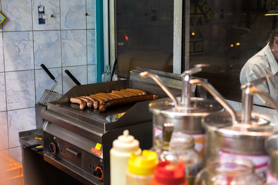 Sausages being grilled on barbecue in commercial kitchen