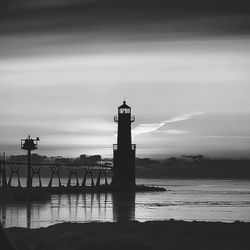 Lighthouse by sea against sky
