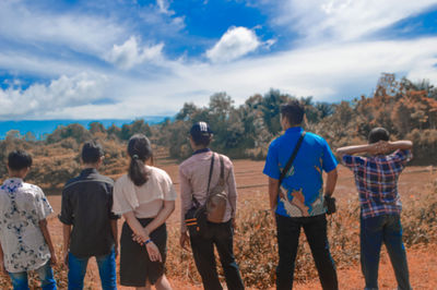 Rear view of people standing against sky