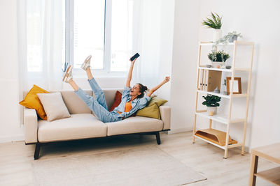 Portrait of woman sitting on sofa at home