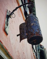 Low angle view of old electric lamp hanging on wall