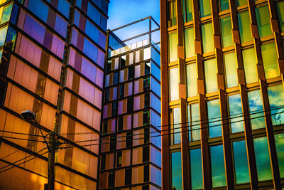 Low angle view of modern glass building against sky