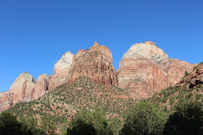 Low angle view of rock formation against clear blue sky