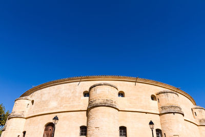 Low angle view of historical building against clear blue sky