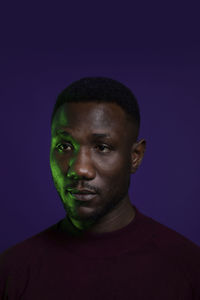 Close-up portrait of young man against black background