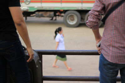 Rear view of people standing on street in city