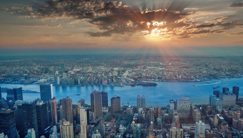 Aerial view of city buildings against sky during sunset