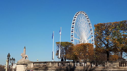 Low angle view of ferris wheel against blue sky