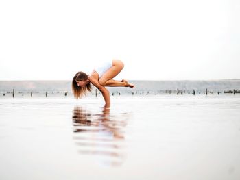 Portrait of woman on beach against clear sky