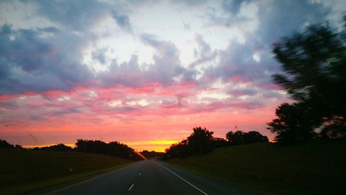 Empty road against cloudy sky