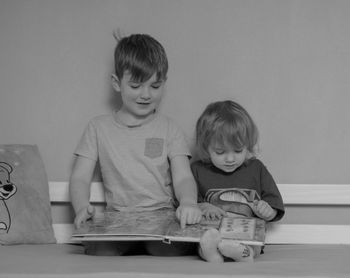 Portrait of siblings sitting on table