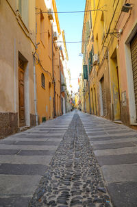 Empty road along buildings