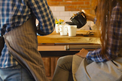 Rear view of man and coffee cup on table