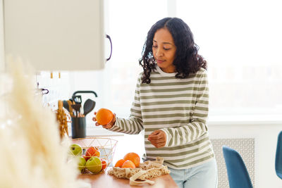 Portrait of young woman using mobile phone at home