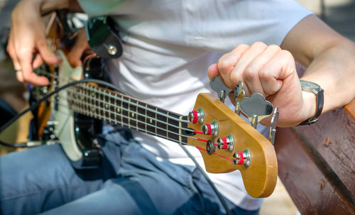 Midsection of man playing guitar