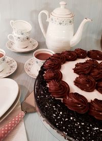 High angle view of tea cups and chocolate cake on table