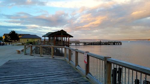 Pier over sea against sky during sunset