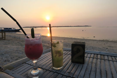 Close-up of drink on table at sunset