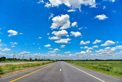 Road passing through land against sky