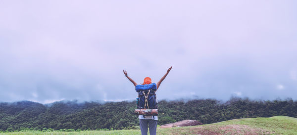 Low angle view of man standing on field against sky