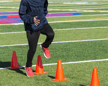 Low section of man playing soccer on field