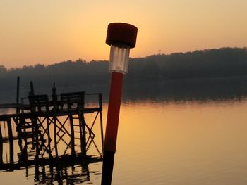 Silhouette pier on lake against sky during sunset