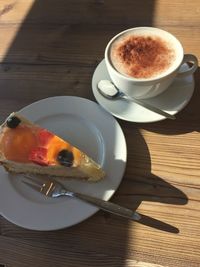 High angle view of cake and coffee on table during sunny day