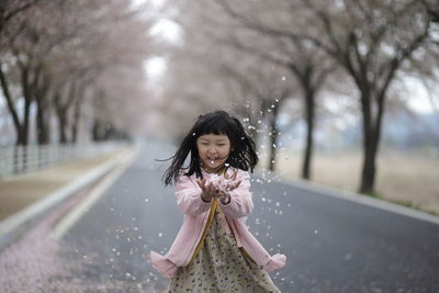 Portrait of cute girl throwing flower petals