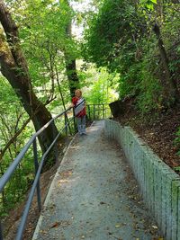 Rear view of man walking on footpath in forest