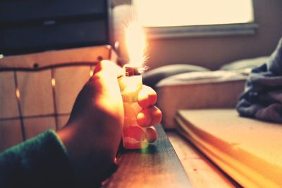 Close-up of hand holding illuminated candles